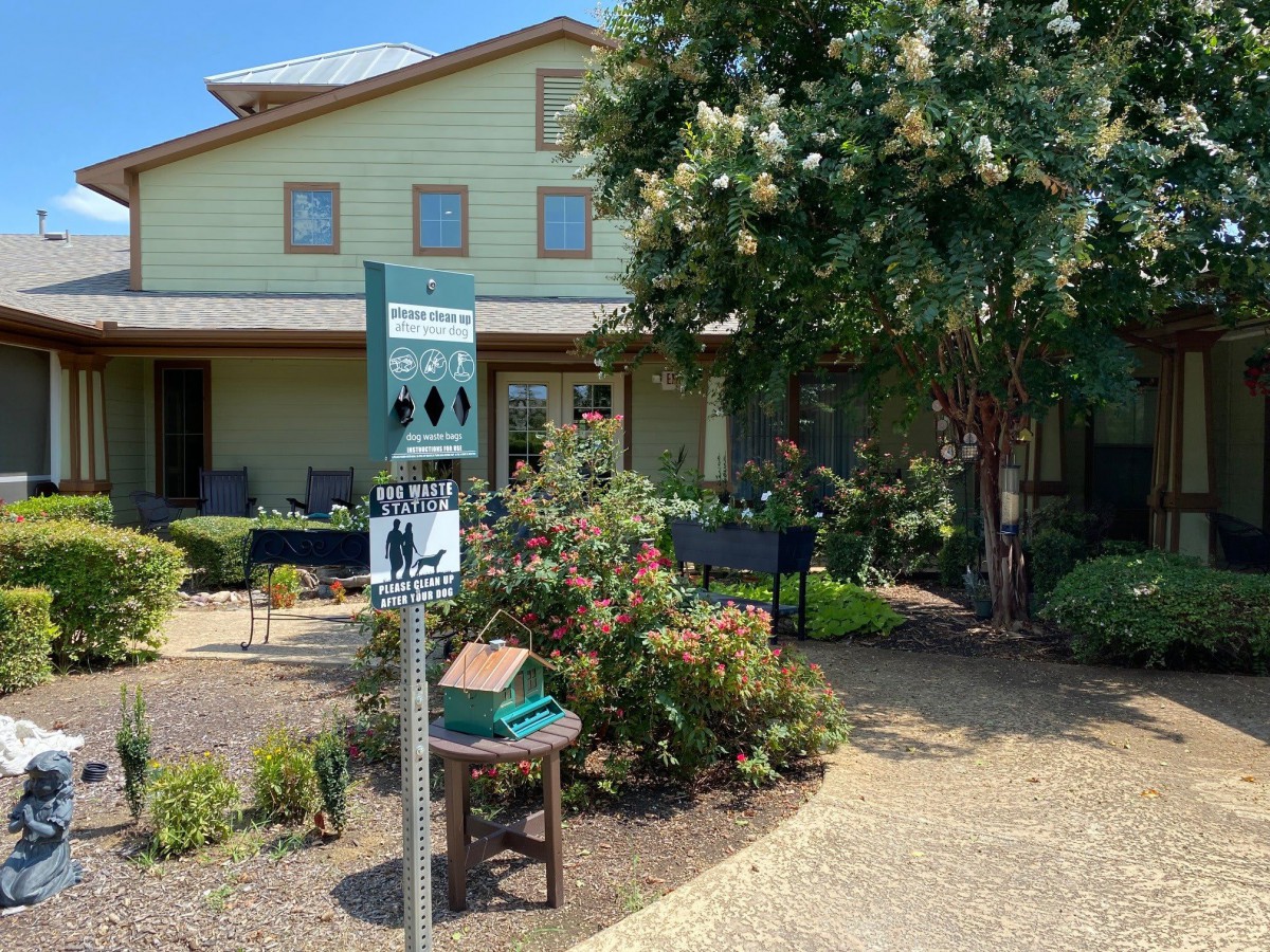 A cozy building with a garden and pathway leading to the entrance.