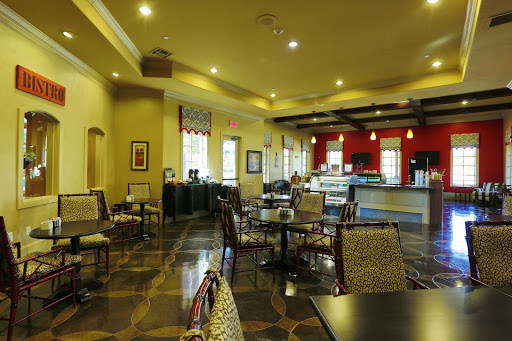 A cozy dining area in a restaurant, featuring elegant chairs and tables under warm lighting.