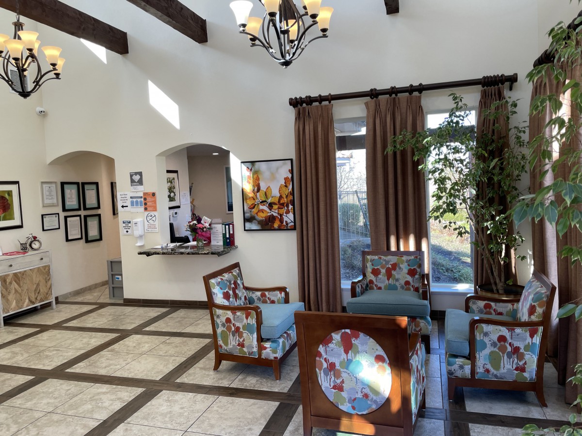 A well-lit reception area with colorful chairs and a chandelier, creating a welcoming atmosphere.