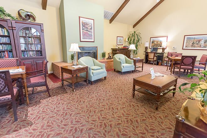 A cozy living room with armchairs, a coffee table, and warm lighting.
