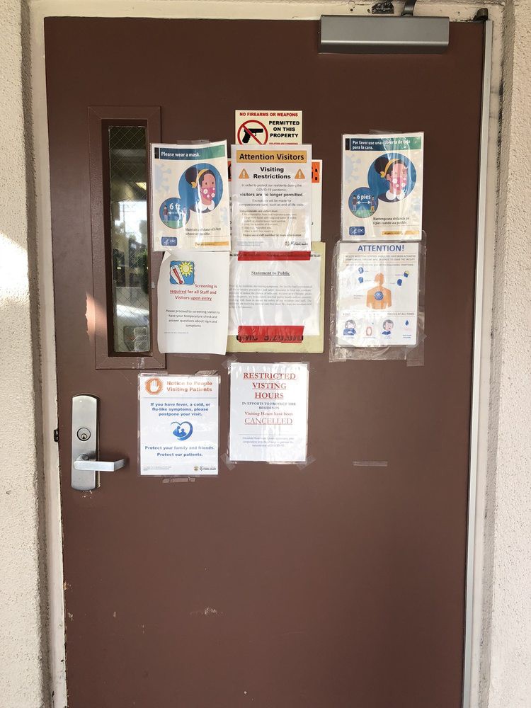 A brown door covered with various informational posters and notices.