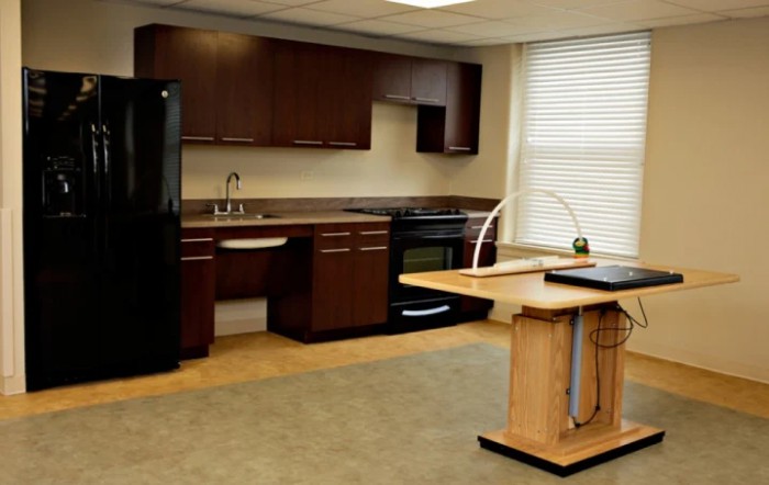 A modern kitchen featuring dark wood cabinets, an island counter, and essential appliances.