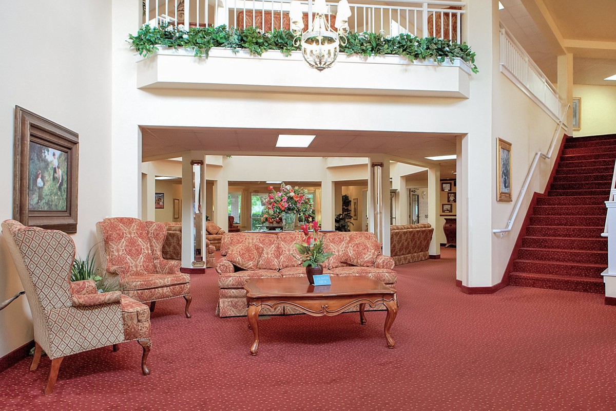 A spacious lobby area with elegant furniture and decorative plants.