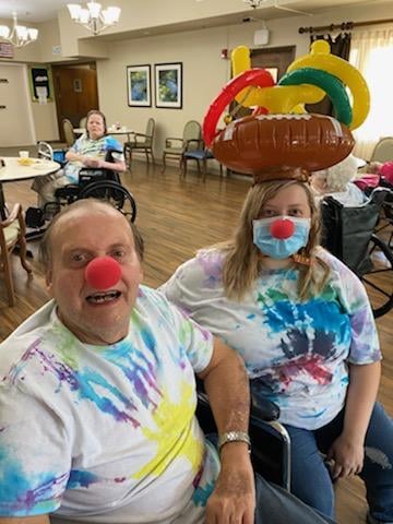 Sharing smiles and laughter with colorful outfits and fun balloon hats in a joyful celebration.
