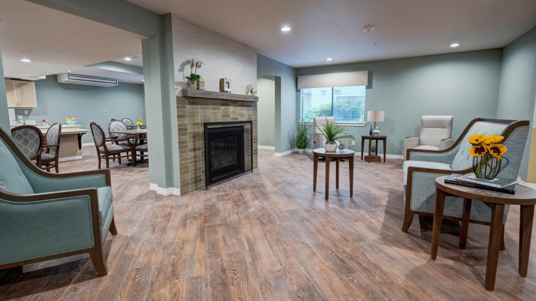 A spacious and cozy living room featuring a modern fireplace, wooden flooring, and elegant decor.