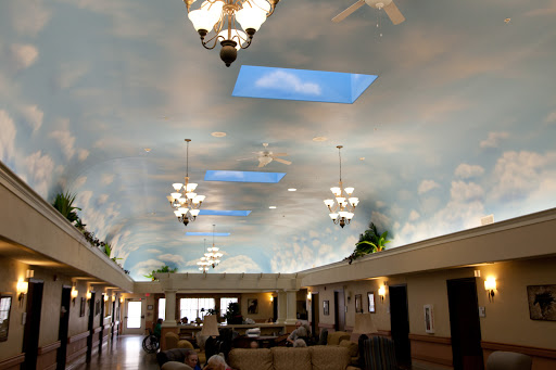 A beautifully designed lobby with a ceiling painted to resemble the sky, featuring chandeliers and comfortable seating.