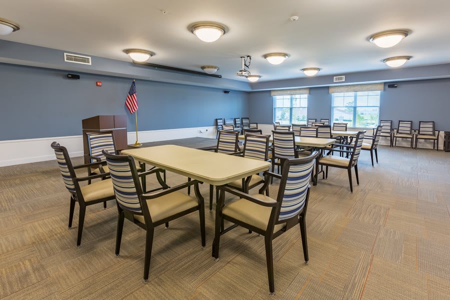 A spacious conference room with tables and chairs arranged for a meeting.