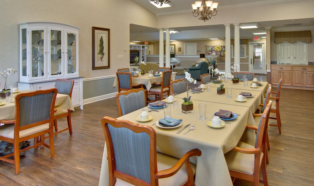 A well-decorated dining area with neatly arranged tables and chairs, set for a formal dining experience.