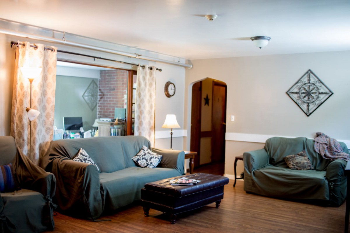 Cozy living room with a sofa, armchair, and warm lighting.