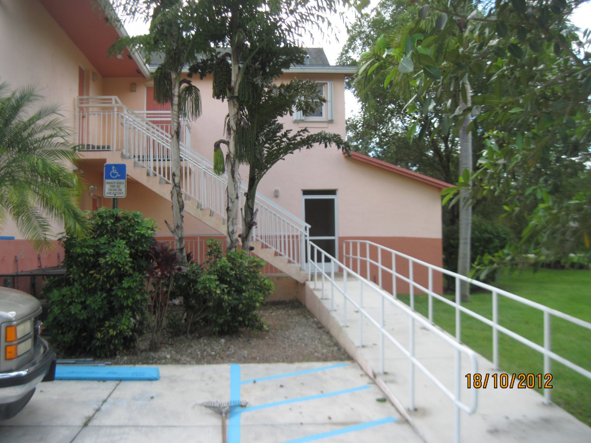 An outdoor ramp leading to a building entrance surrounded by trees.