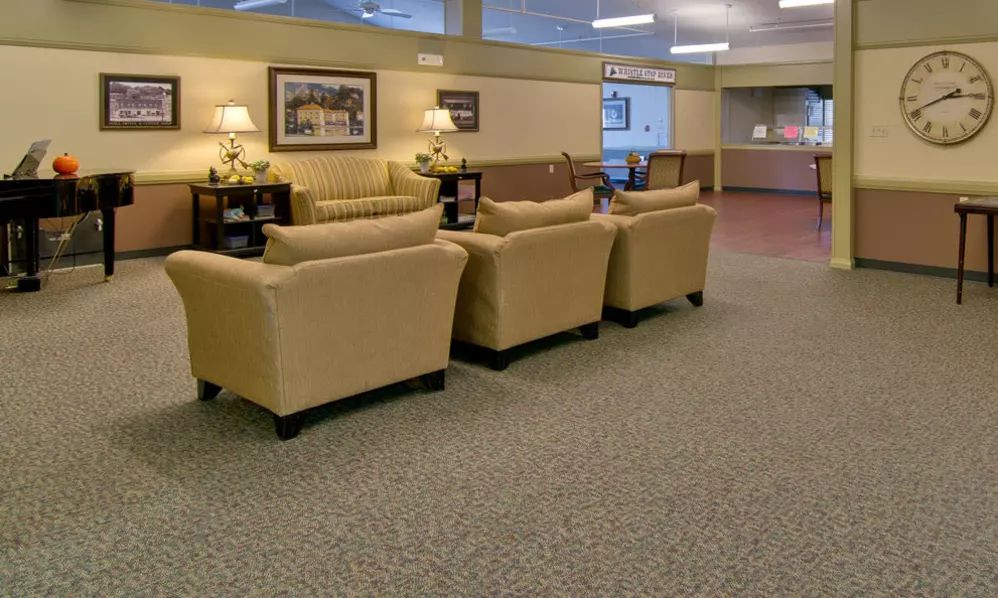A comfortable waiting area with beige sofas and warm lighting.