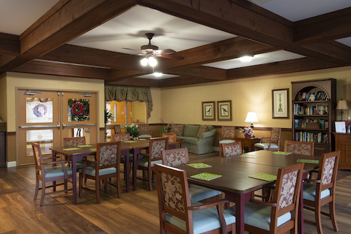 A cozy dining area featuring wooden beams, stylish furniture, and warm lighting.
