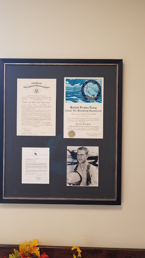 A collection of framed certificates and a black-and-white photograph, showcasing achievements and recognition.