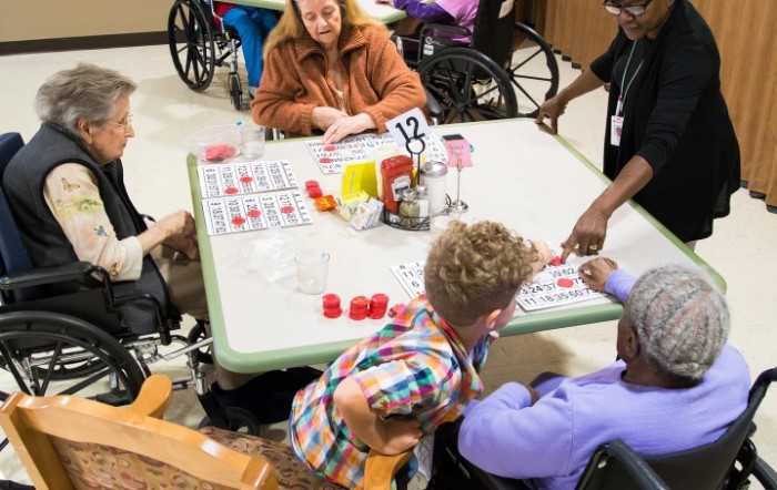 Seniors and caregivers enjoy a bingo game at a nursing home.