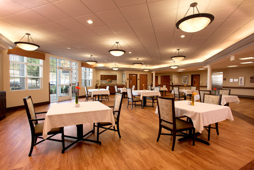 A spacious dining area with elegantly set tables and warm lighting.
