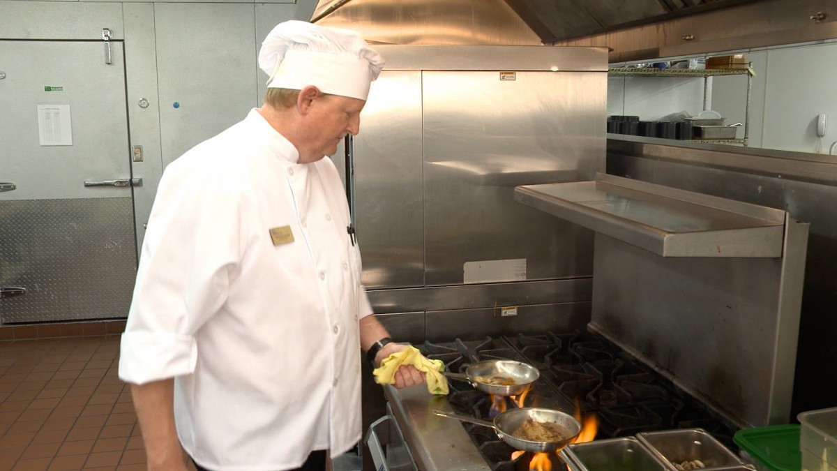 A chef is cooking in a professional kitchen.