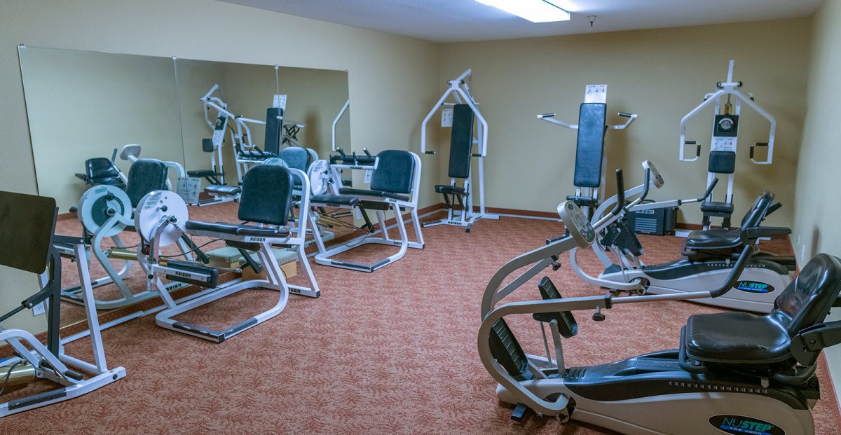 A gym with various exercise machines and equipment.