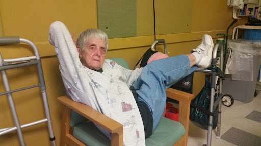 An elderly person relaxing in a chair with their legs stretched out.