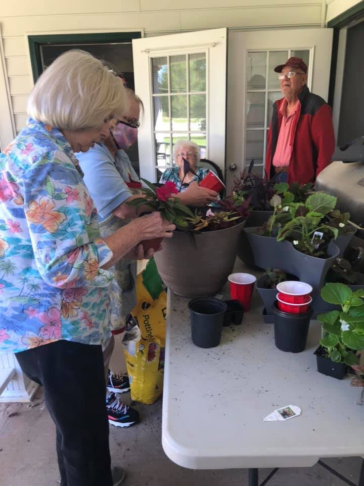 People gathered around a table engaged in gardening activities.