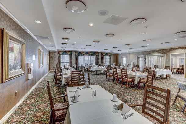 A spacious dining area with neatly arranged tables and chairs, ready for guests.