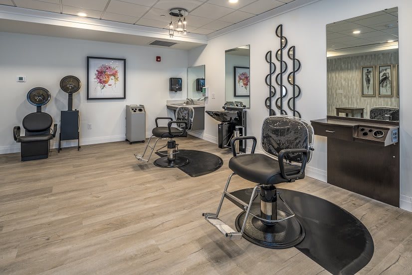 A modern hair salon with stylish chairs and mirrors, featuring a clean and contemporary design.