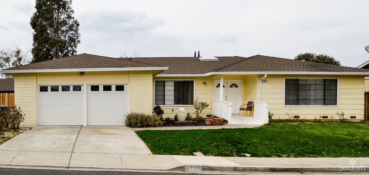 A single-story suburban house with a well-maintained lawn and driveway.