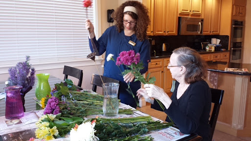 Two women enjoy a leisurely afternoon creating floral arrangements together.