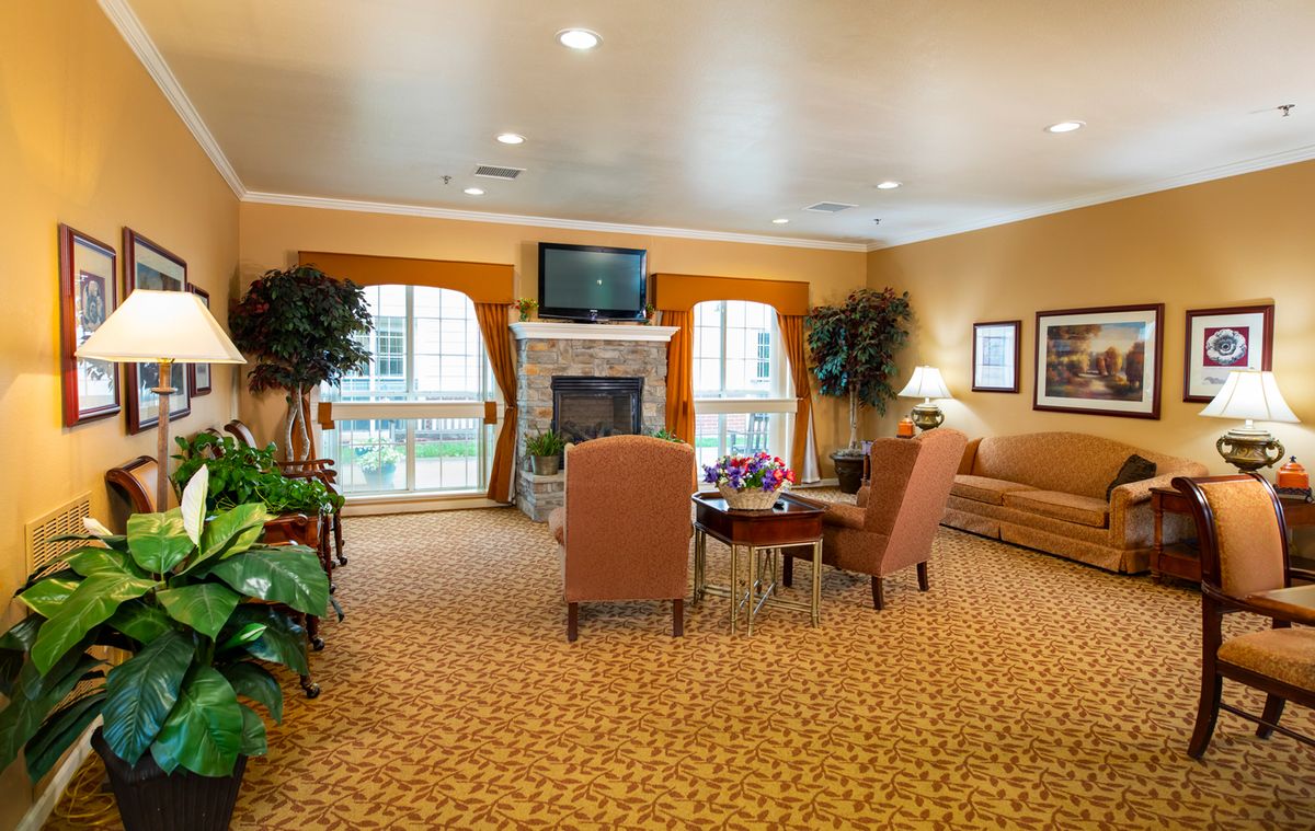 A cozy living room with comfortable seating, a fireplace, and a television.