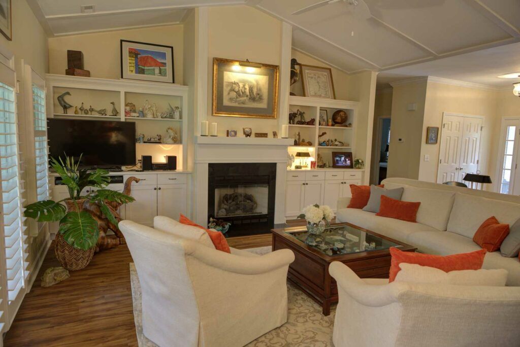 A cozy living room with a central fireplace, surrounded by comfortable seating and decorative shelves.