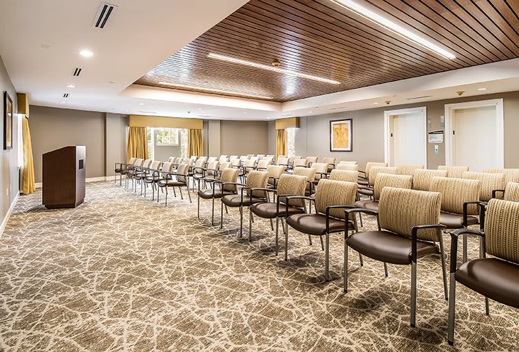 A modern conference room set up with rows of chairs ready for a meeting or presentation.
