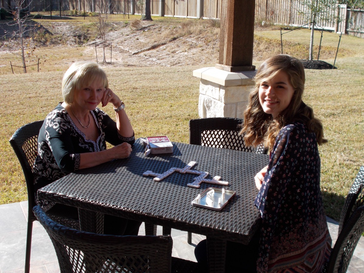 Two people sitting at an outdoor table in the sun.