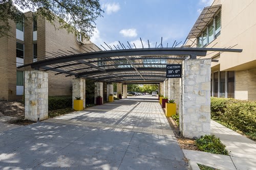 A modern building entrance with a covered walkway on a sunny day.
