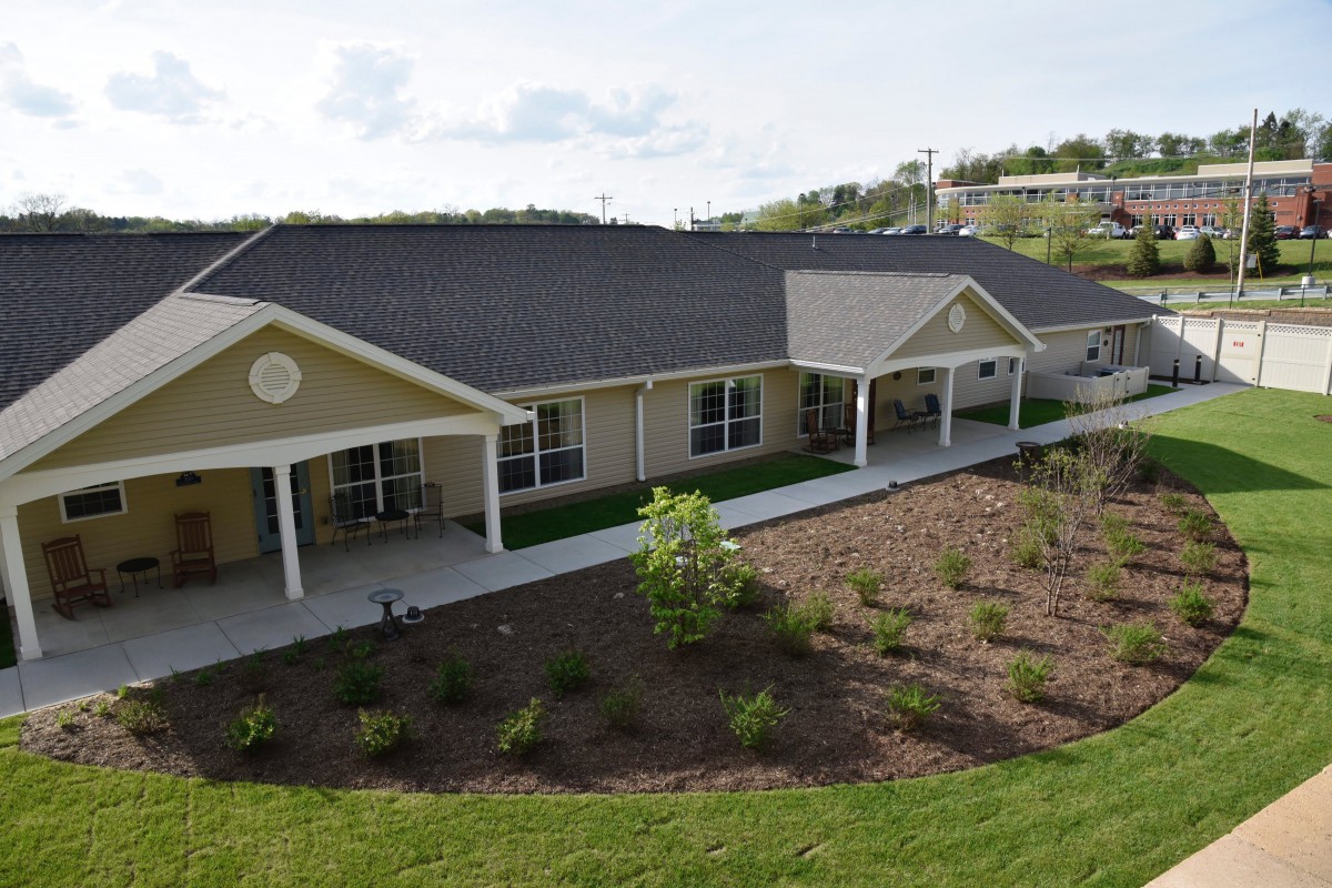A modern single-story building surrounded by a landscaped garden.