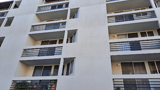 A modern apartment building featuring multiple balconies and a clean exterior.