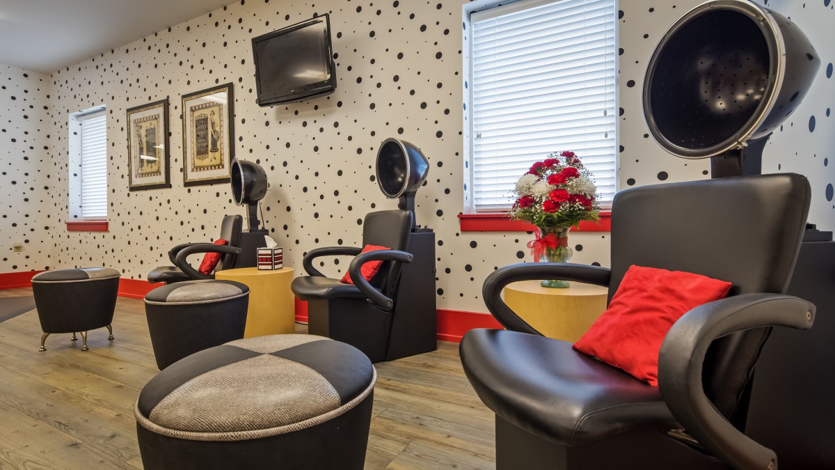 A cozy salon interior with stylish hairdressing chairs and vibrant decor.