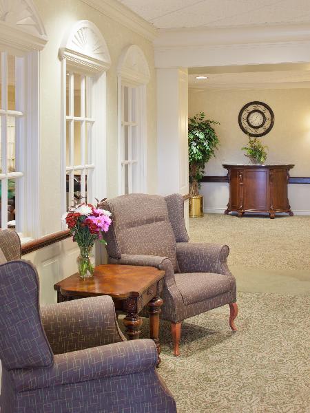 A cozy lobby with comfortable chairs and a small table adorned with flowers.