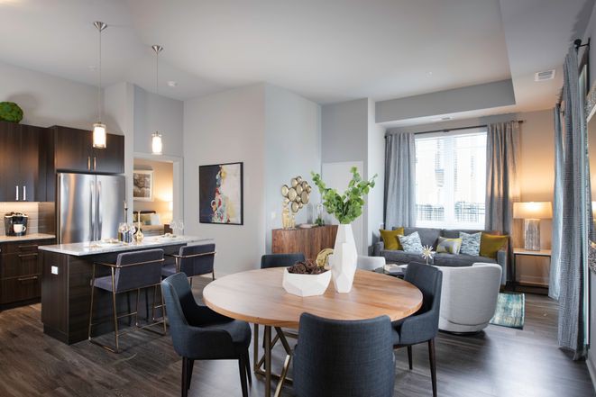 A modern living and dining area with an open layout, featuring elegant furniture and ample natural light.