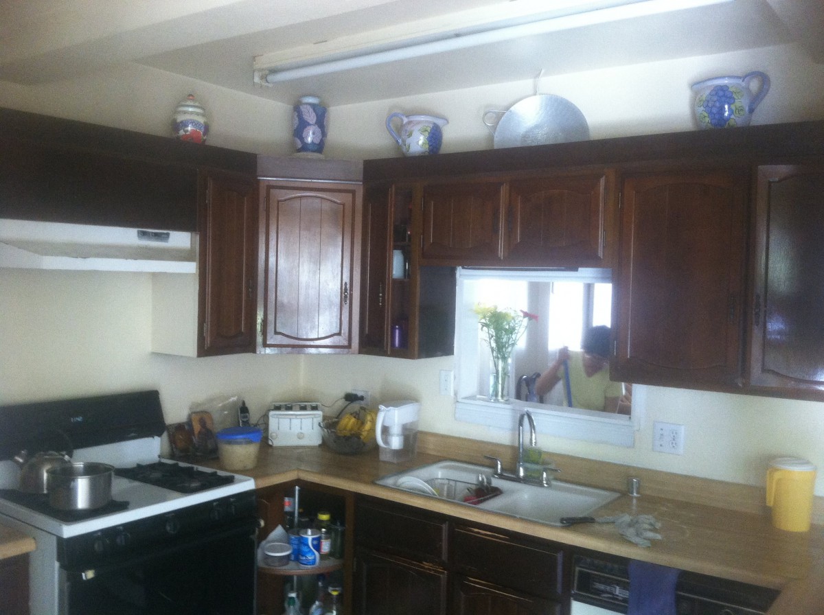 A cozy kitchen featuring dark wooden cabinets and a neatly organized countertop.