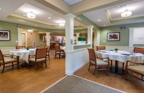 A well-lit dining area with neatly arranged tables and chairs.