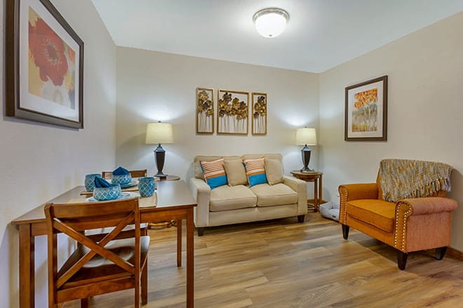 A cozy and stylish living room featuring a comfortable sofa, dining set, and tasteful decor.