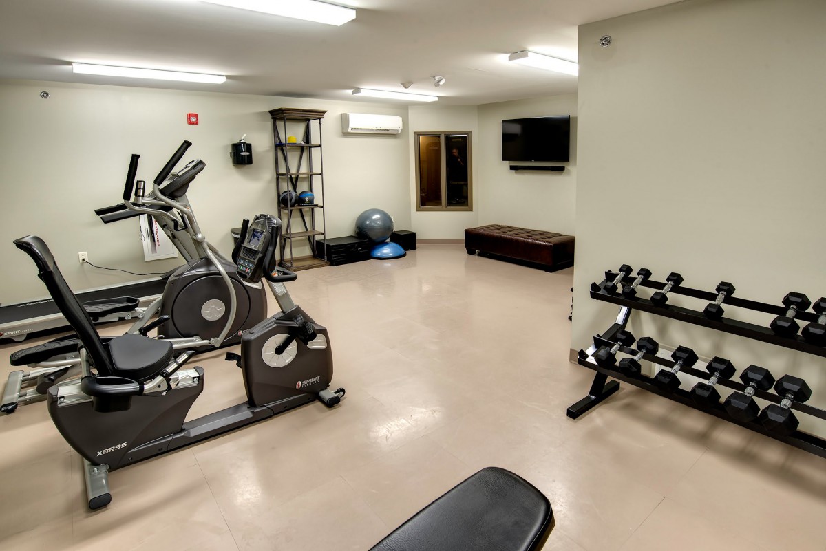 A small gym equipped with exercise machines and weights.