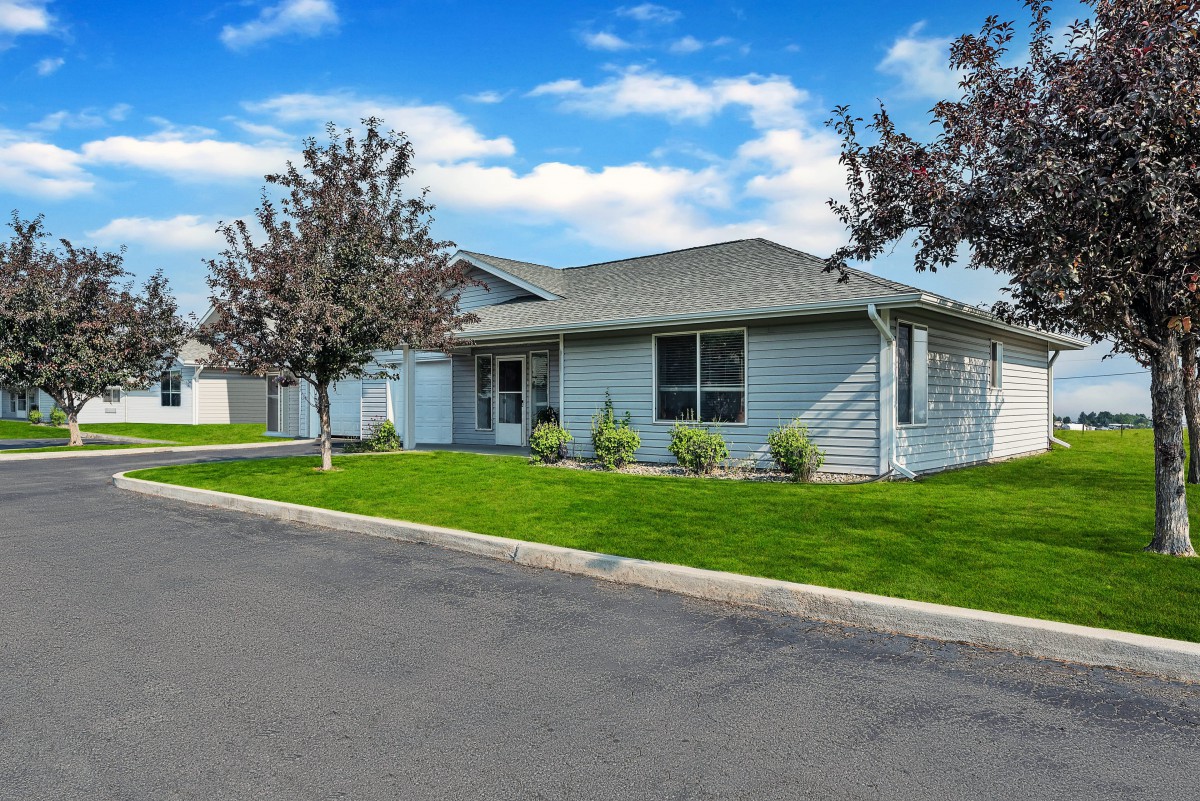 A suburban house with a well-maintained lawn and clear blue sky.