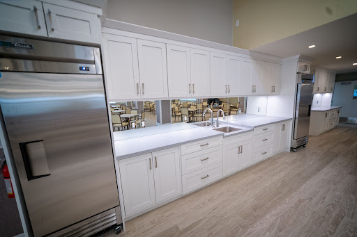 A modern kitchen featuring sleek white cabinetry and stainless steel appliances, creating a clean and minimalist look.