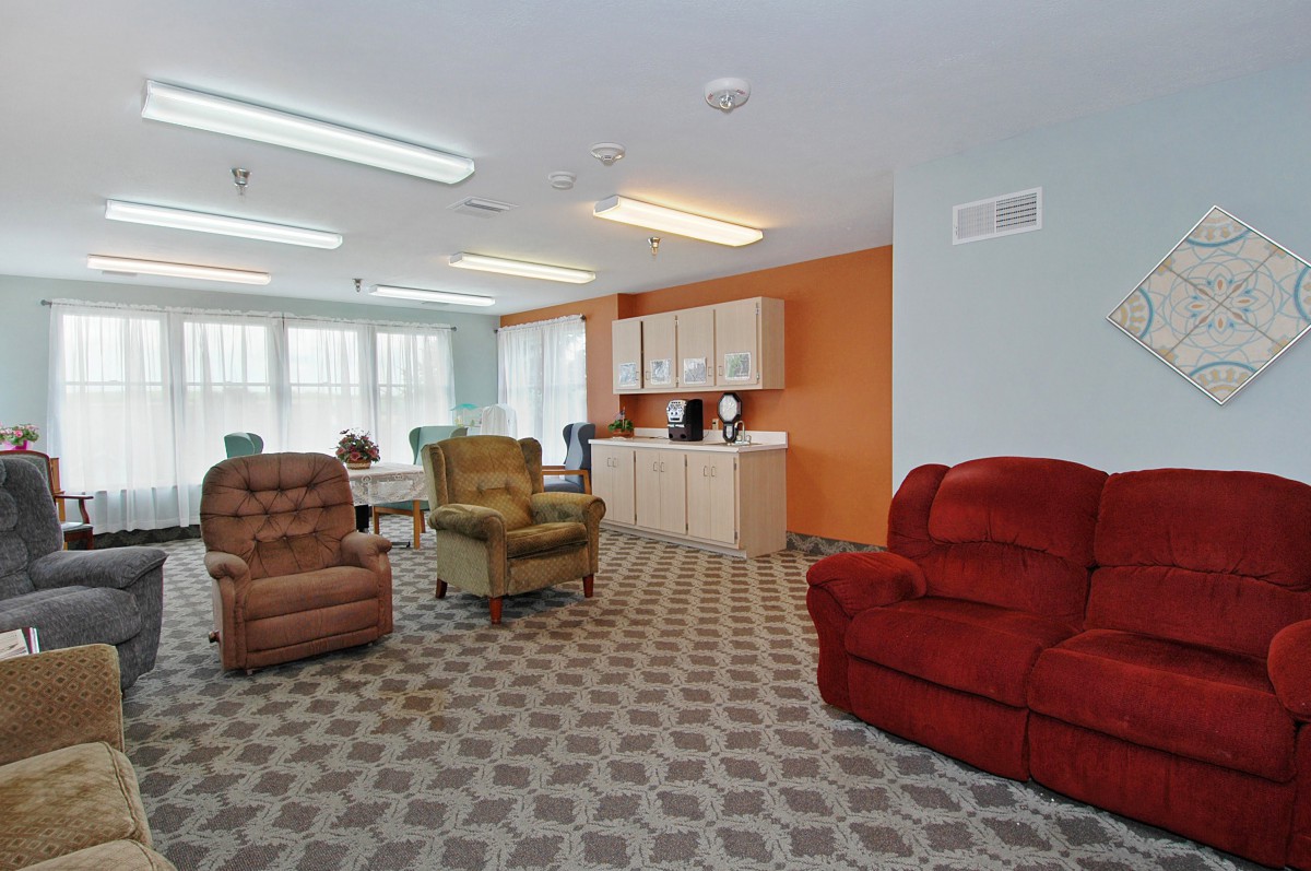 A cozy living room featuring colorful chairs and a patterned carpet.