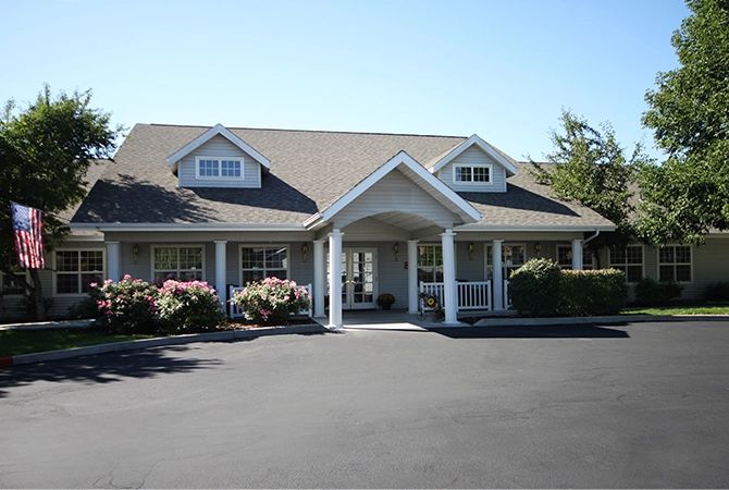A suburban house with a covered entrance and landscaped surroundings.