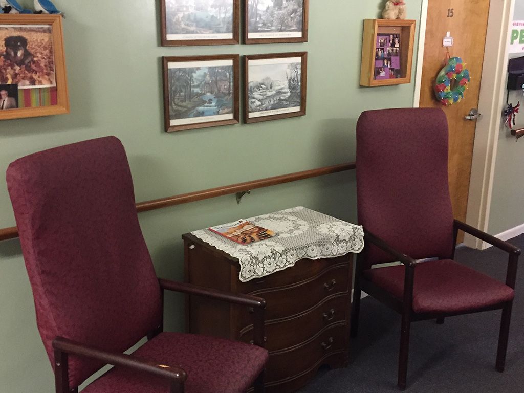 A cozy waiting area with chairs and framed pictures on the wall.
