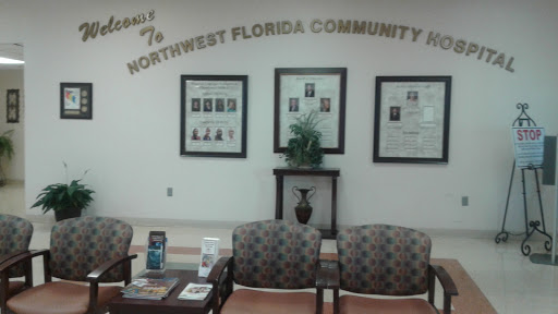 A waiting area in Northwest Florida Community Hospital featuring comfortable chairs and framed photographs.