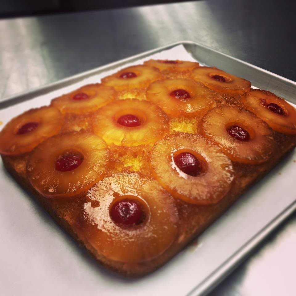 A freshly baked pineapple upside-down cake topped with cherries.