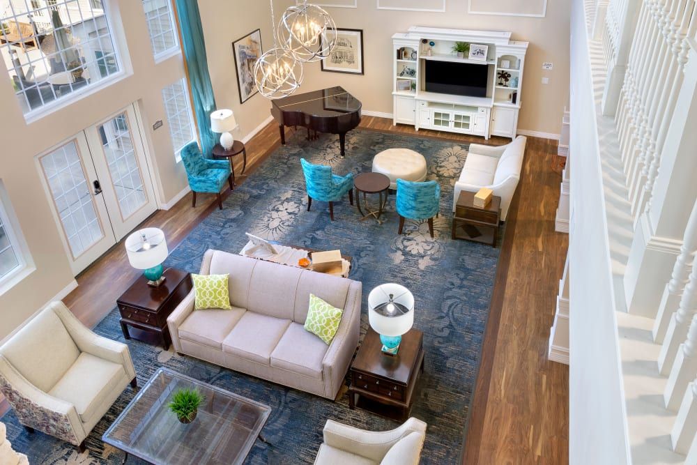 A spacious and elegantly designed living room featuring a grand piano, modern furniture, and an entertainment center.