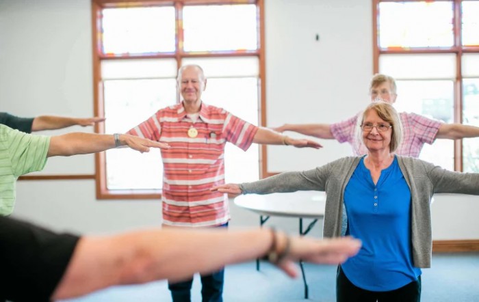 A group of seniors participating in a fitness class at a community center.